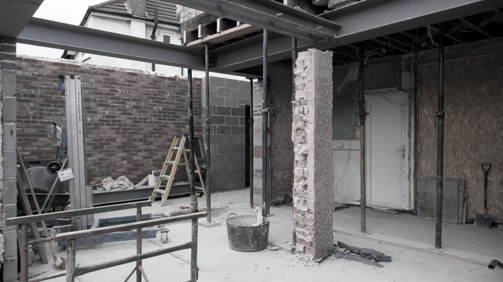 Internal steel frame and brick pier supporting a house during structural alterations