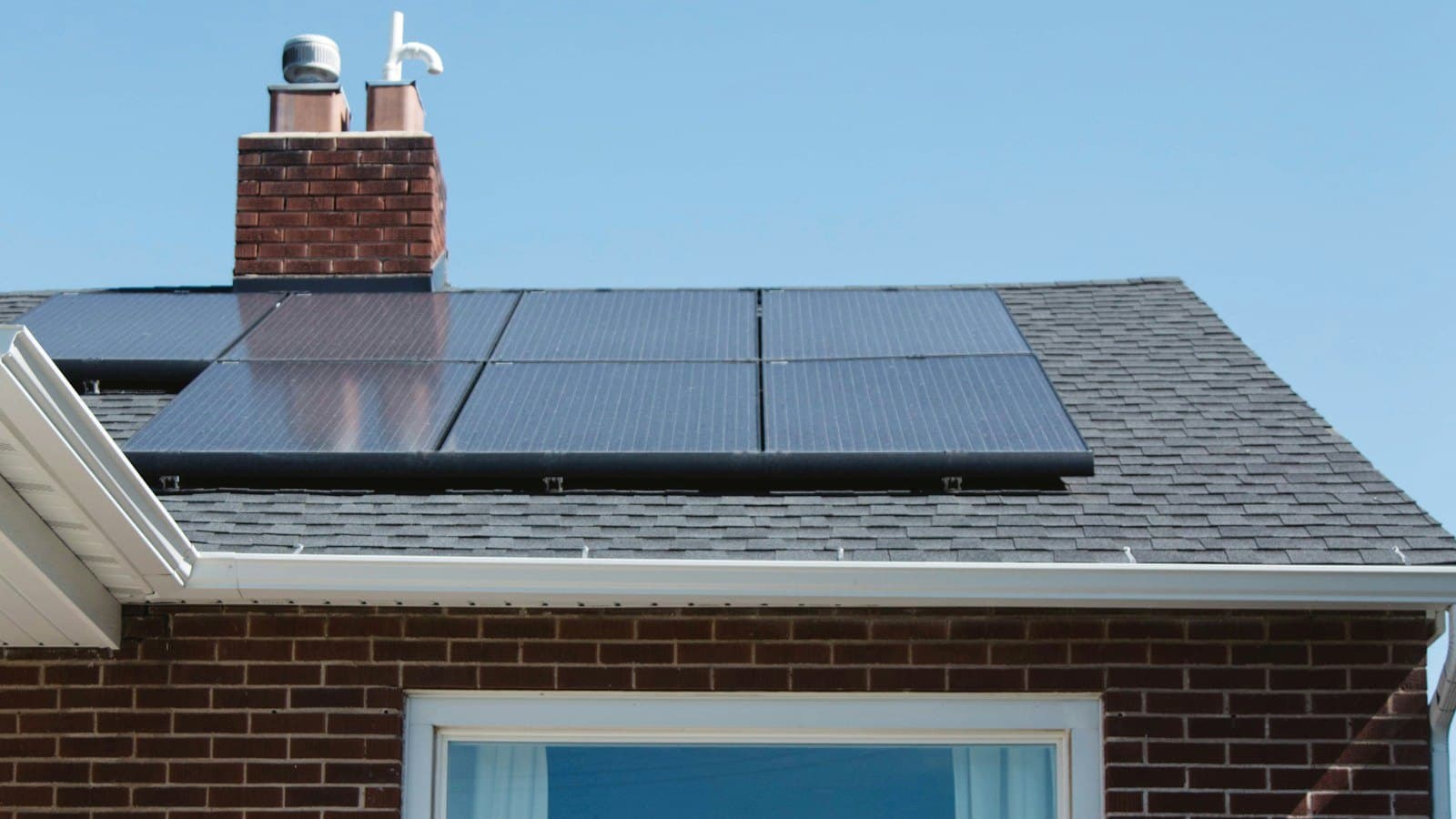 Solar panels on the pitched roof of a brick house