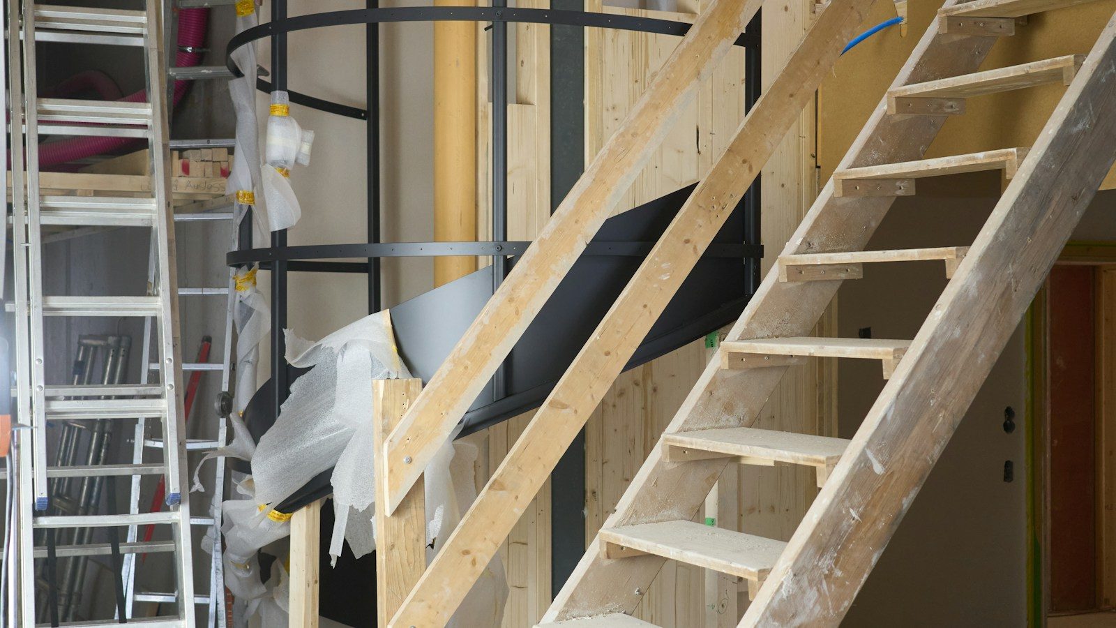 Timber stair strings and treads rising to the edge of an upper floor on a building site