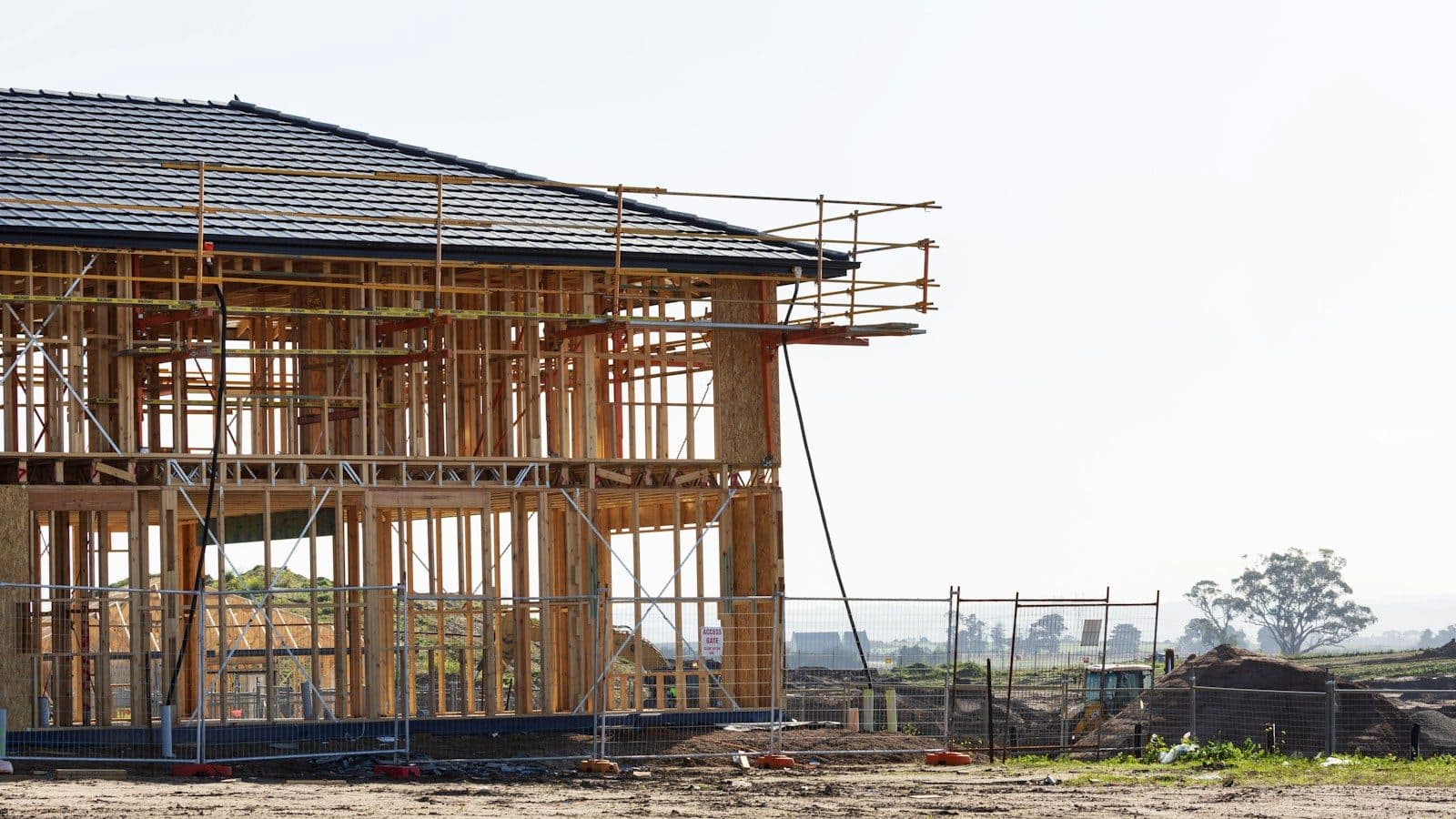 Two-storey wood-frame house under construction with scaffolding